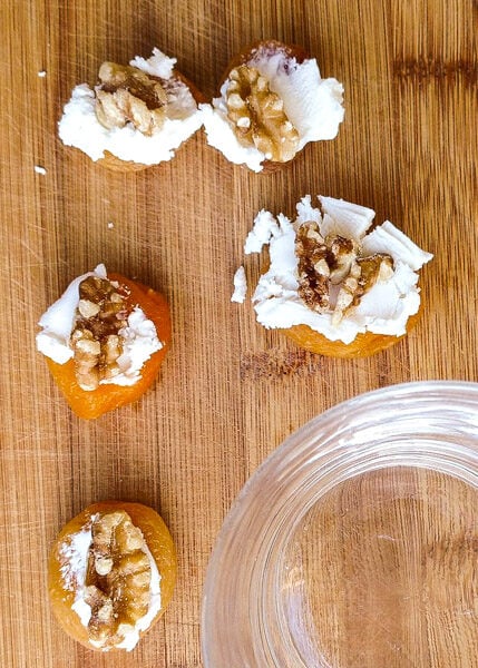 Apricot and goat cheese snack on wooden surface