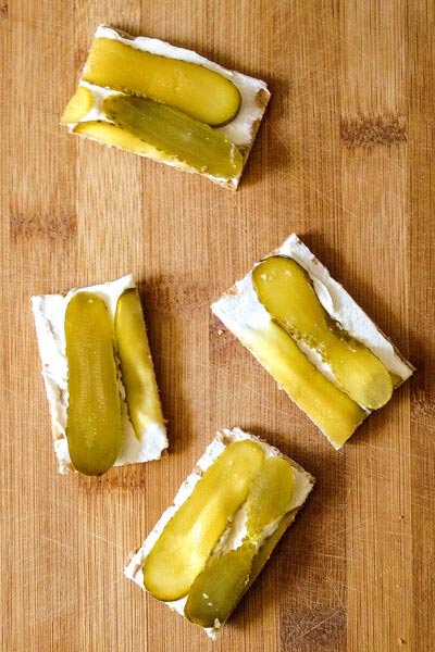 Gherkin on crispbread snack on wooden surface