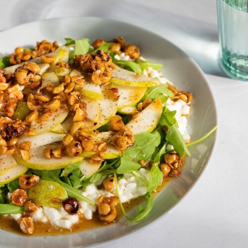 Cottage cheese salad served on a white plate which is on a light surface. Next to it, there is a glass of water | Hurry The Food Up