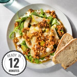 Bird's-eye view of cottage cheese salad and two pieces of bread served on a white plate which is on a light surface with a time badge in the bottom left corner | Hurry The Food Up