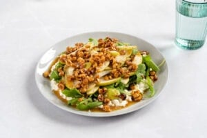 Cottage cheese salad served on a white plate which is on a light surface. Next to it there is a glass of water | Hurry The Food Up