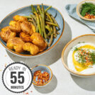 The bowl with smashed potatoes and green beans is on the grey surface. Near it, there are smaller bowls with feta dipping sauce, sweet paprika flakes, dill. There is a time badge in the bottom left corner | Hurry The Food Up