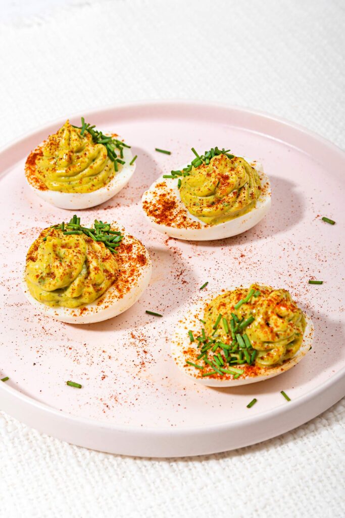 The avocado deviled eggs are served on the white plate that is on the table | Hurry The Food Up