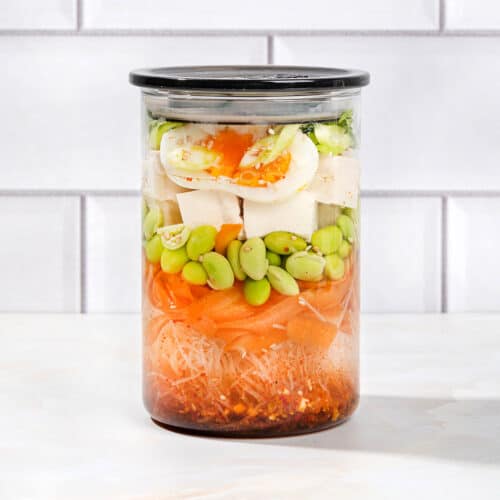 A sealed jar of all the constituent ingredients of an easy homemade ramen noodle soup, on a white surface | Hurry The Food Up