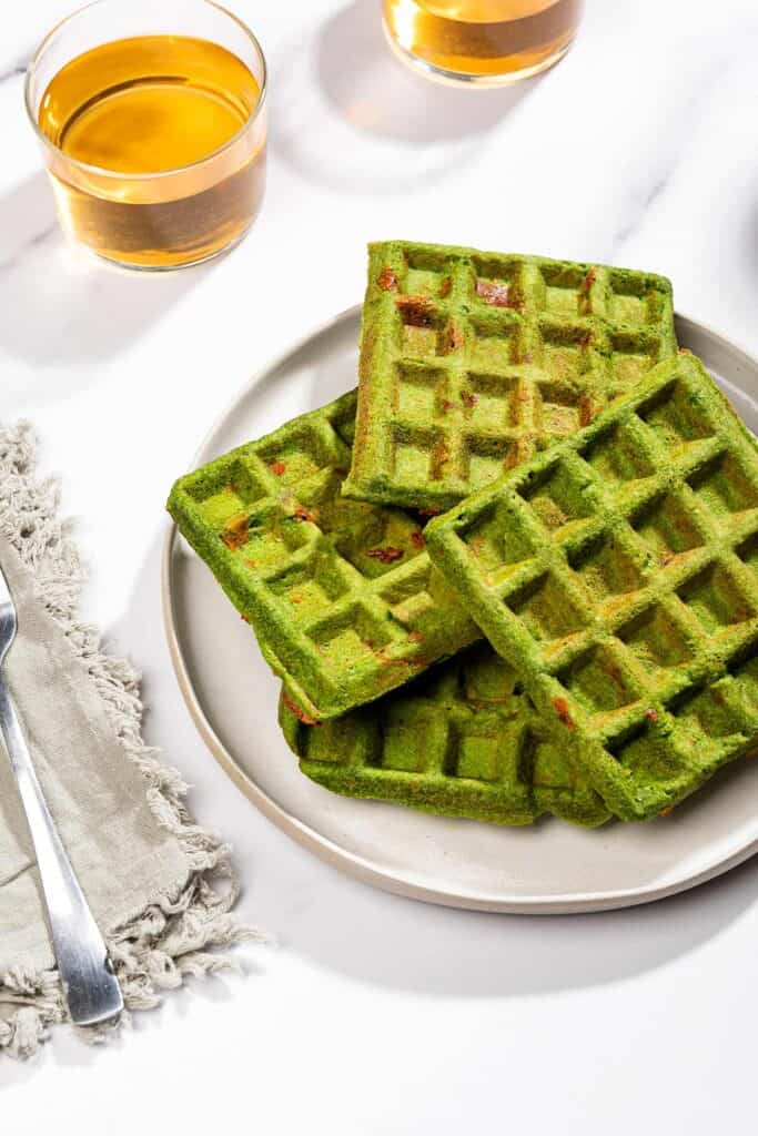 Four green waffles on a plate with a fork and two glasses with drink | Hurry The Food Up