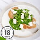 Toasted bread slice that is on the white plate is topped with beans, green sauce and crumbled cheese with a time stamp in the bottom left hand corner | Hurry The Food Up