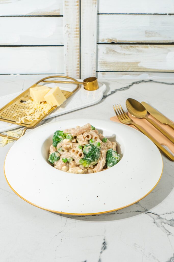 A bowl of mac and cheese on a marble table with wooden backdrop | Hurry The Food Up