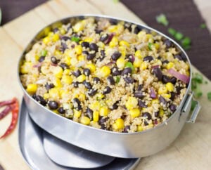 A big black bowl with high protein black bean salad with corn, that is on the wooden surface | HurryTheFoodUp