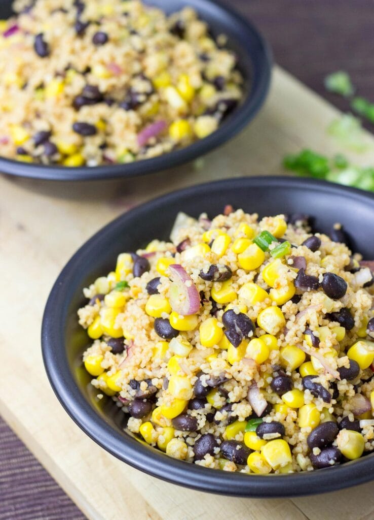 Two black bowls with high protein black bean salad with corn, that are on the wooden surface | HurryTheFoodUp