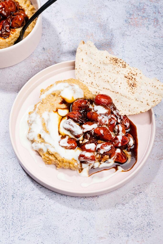 Masabacha dip is served on a plate with cherry tomatoes, low fat yogurt and flatbreads | Hurry The Food Up