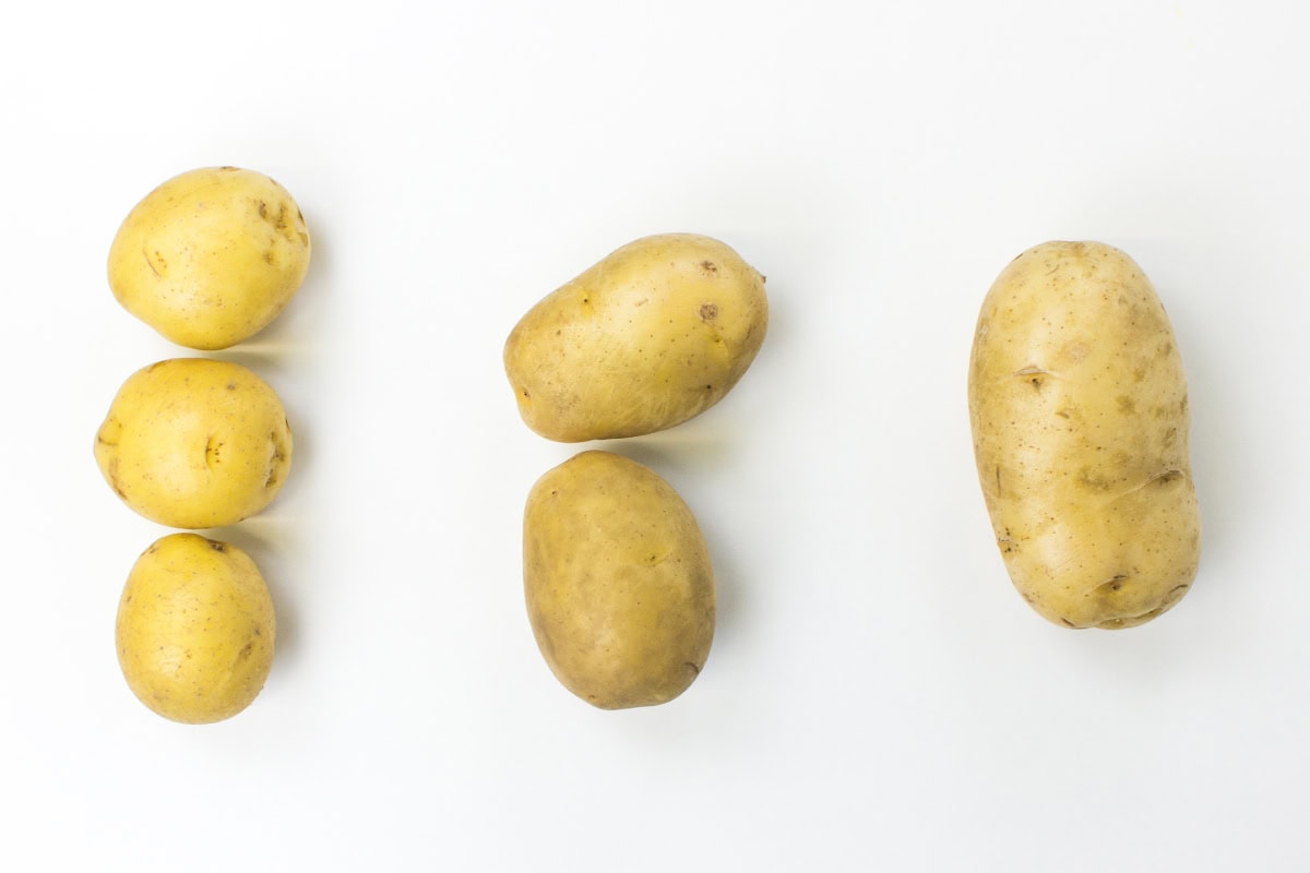 Some potatoes are on a light surface. The baking time in the microwave oven depends on the size of the potato | HurryTheFoodUp