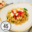 Easy high-protein millet pilaf topped with baked feta is on the light plate with a time badge in the bottom left corner | Hurry The Food Up