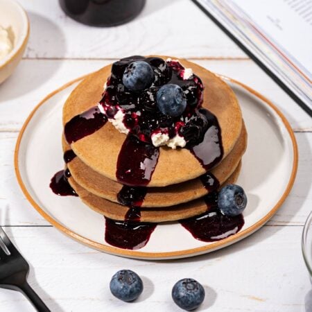 A plate of oatmeal pancakes topped with blueberry syrup and cottage cheese | Hurry The Food Up