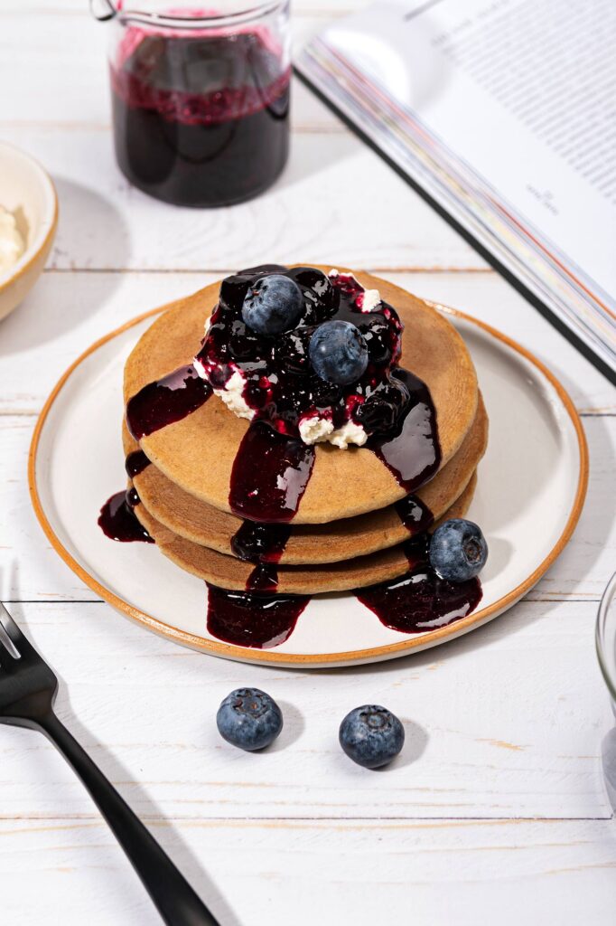 A plate of oatmeal pancakes topped with blueberry syrup and cottage cheese | Hurry The Food Up