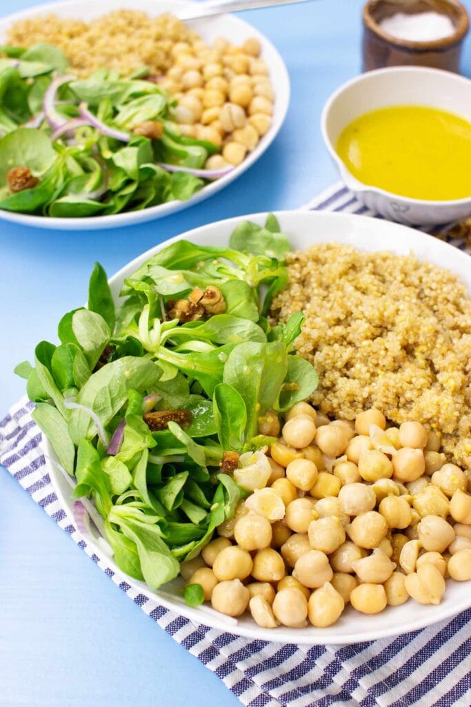 The meal with corn salad are on the table on 2 plates with towel, salt and dressing #olive oil #white vinegar | hurrythefoodup.com