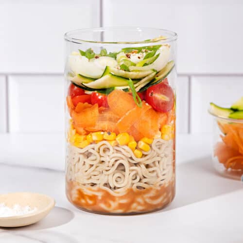 An open jar in the process of being layered with lots of ingredients including zucchini, carrot, salt | Hurry The Food Up