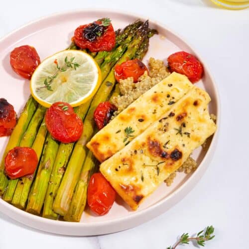 A plate of roast asparagus, halloumi and tomatoes, on a bed of quinoa with a jar of olive oil in shot | Hurry The Food Up