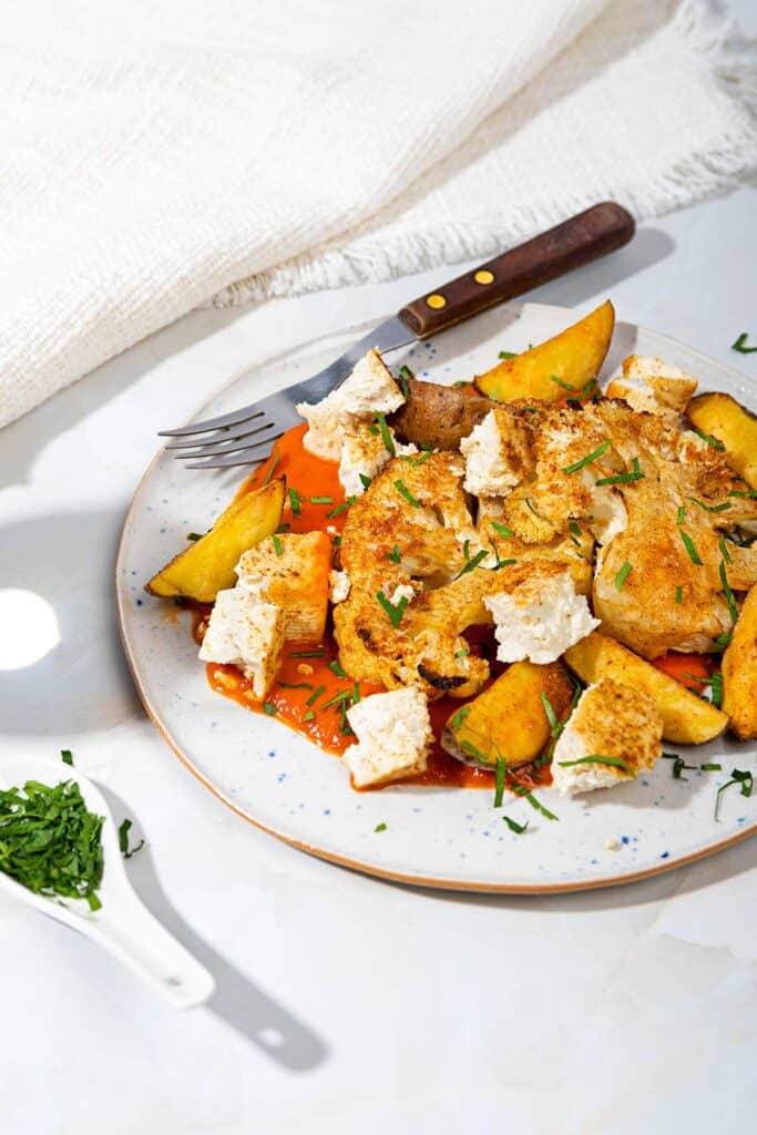 A plate of roasted cauliflower steak with sauce, with a fork and a spoon of herbs | Hurry The Food Up