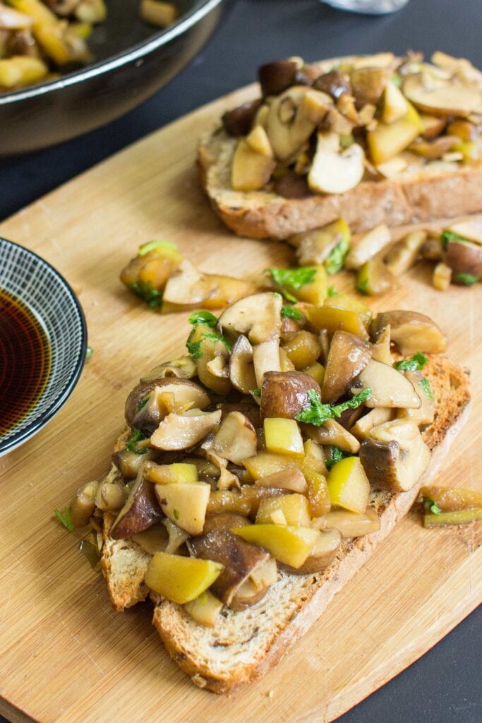 The toasts are on the chopping board on a table with soy sauce and a pan with mushrooms | Hurry The Food Up