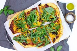 The pizza is served on the paper on a chopping board on a towel with olive oil, salt and basil leaves #oregano #red onion | hurrythefoodup.com