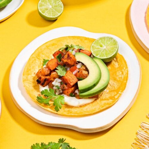 A sweet potato taco is assembled on a plate on a yellow surface | Hurry The Food Up